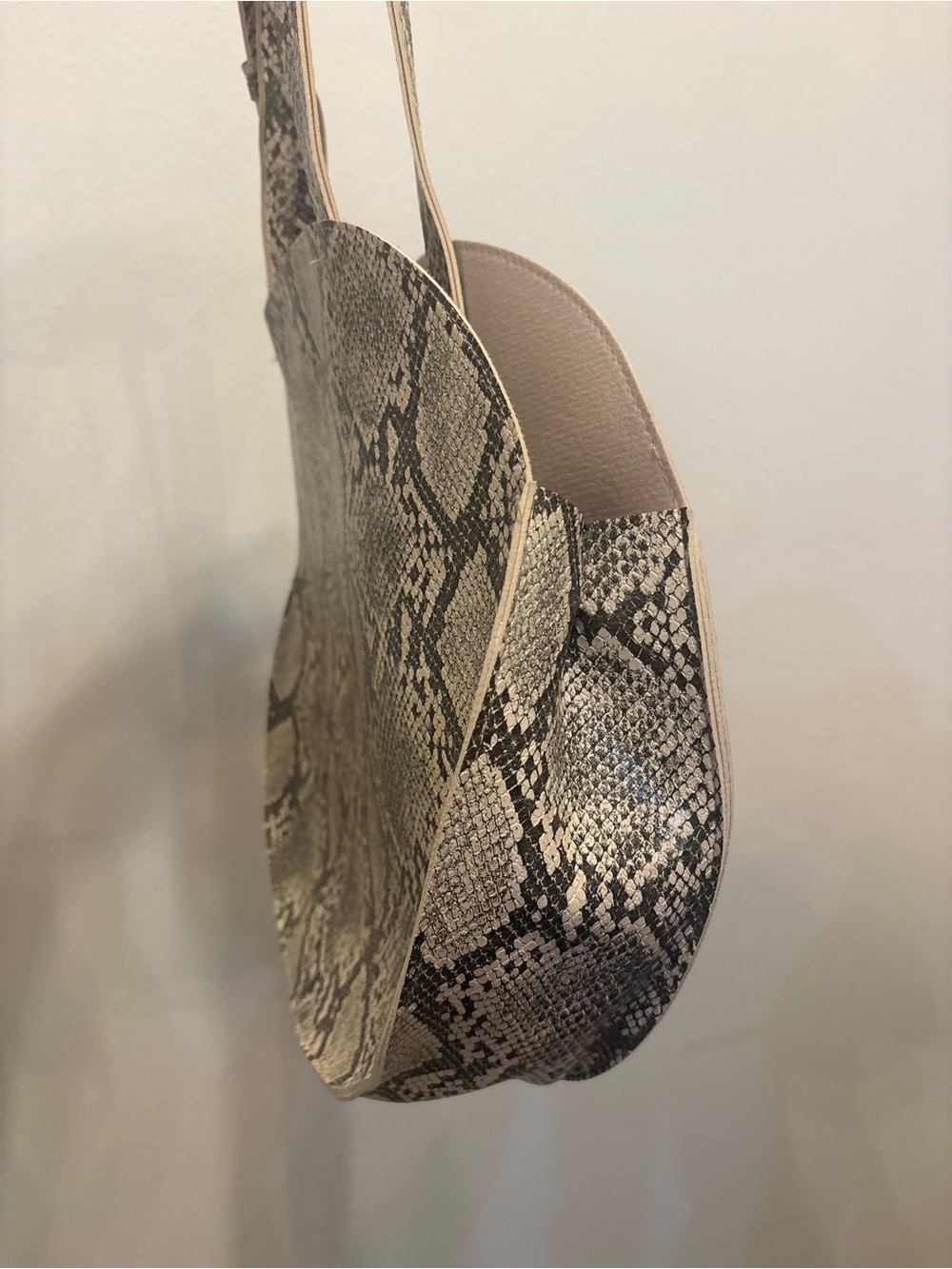 Chic round circular tote bag featuring a neutral gray and cream snakeskin/python